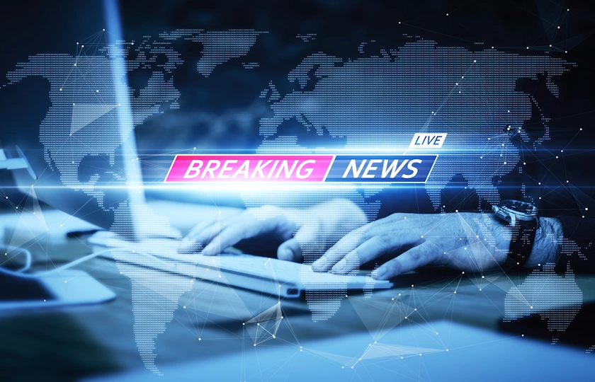 mani digitano su una tastiera , al centro la scritta breaking news