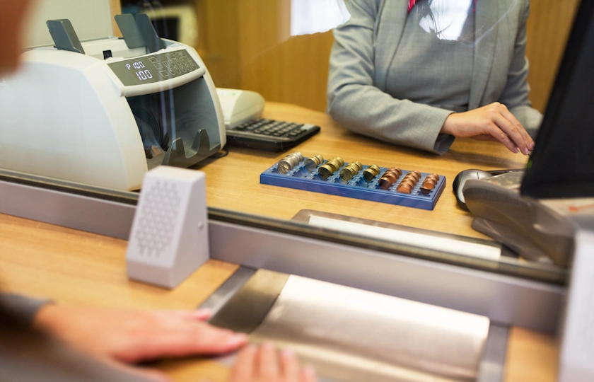impiegato di banca serve un cliente allo sportello